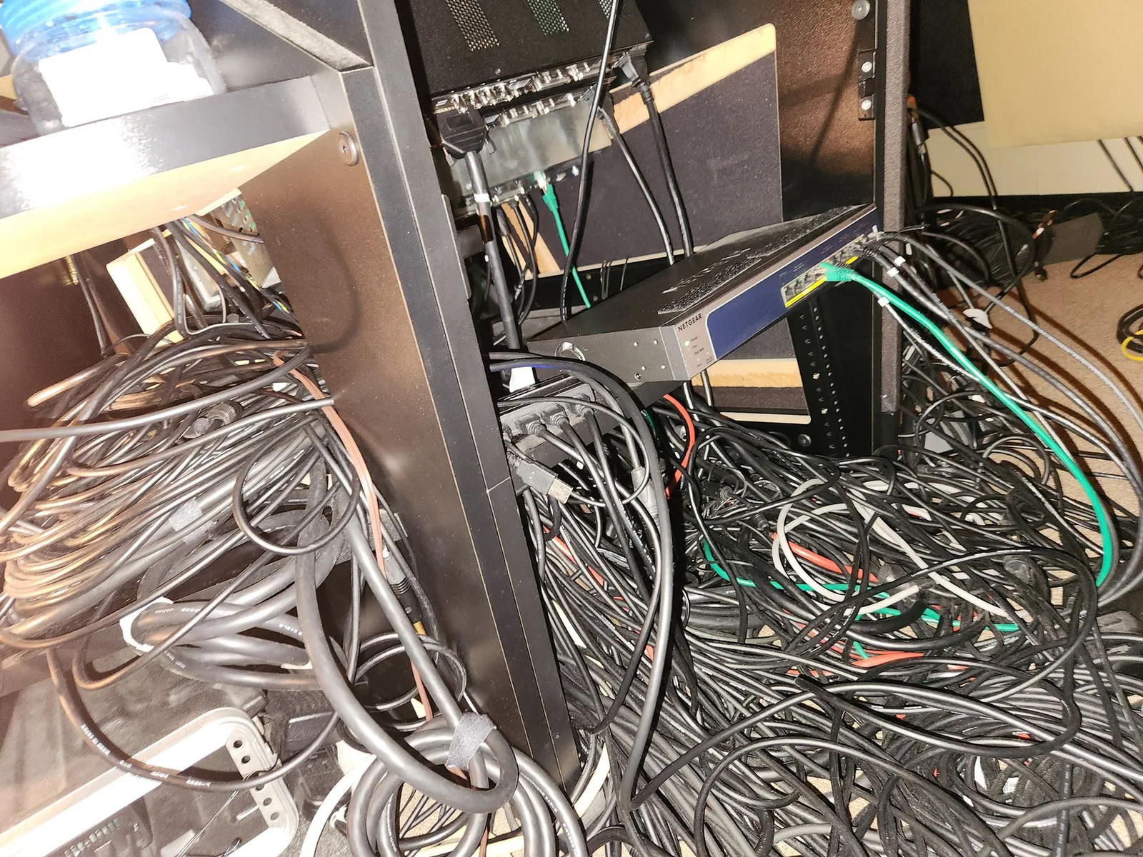 Photo of the rear of a studio equipment rack showing a dense arrangement of cables and connectors wired into the back of a patchbay.