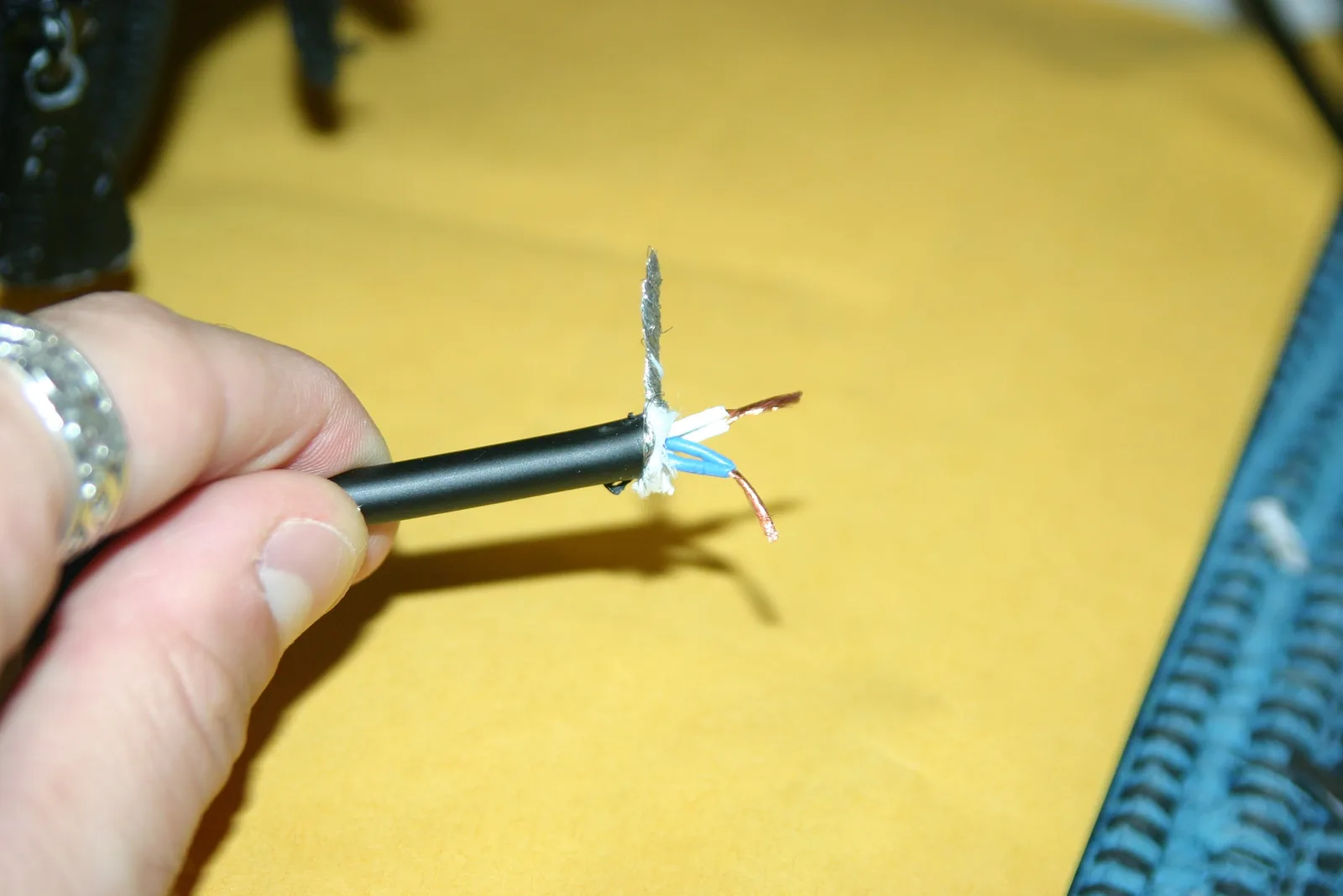 Photo of a balanced audio cable with the outer jacket stripped, the braided shield twisted into a drain lead, and the hot and cold conductor pairs separated and stripped.