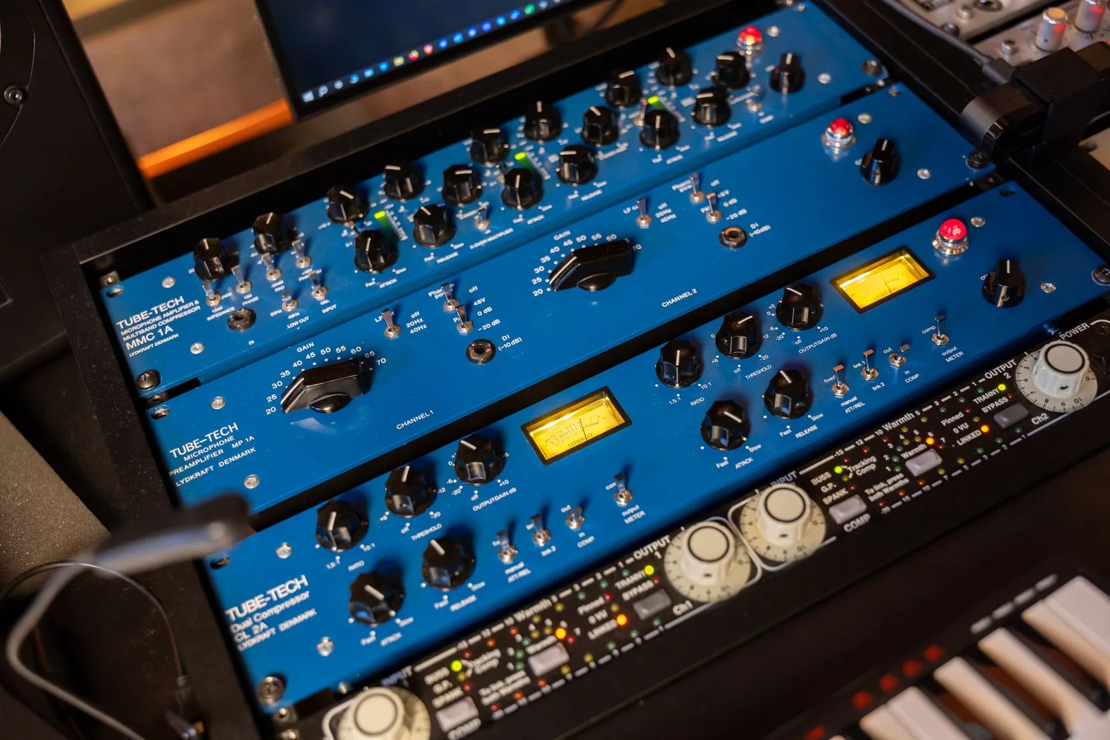 Photo of a Tube-Tech rack showing a MMC 1A microphone amplifier and multiband opto compressor, MP 1A preamp, and CL 2A dual opto compressor, with an Empirical Labs Fatso below.