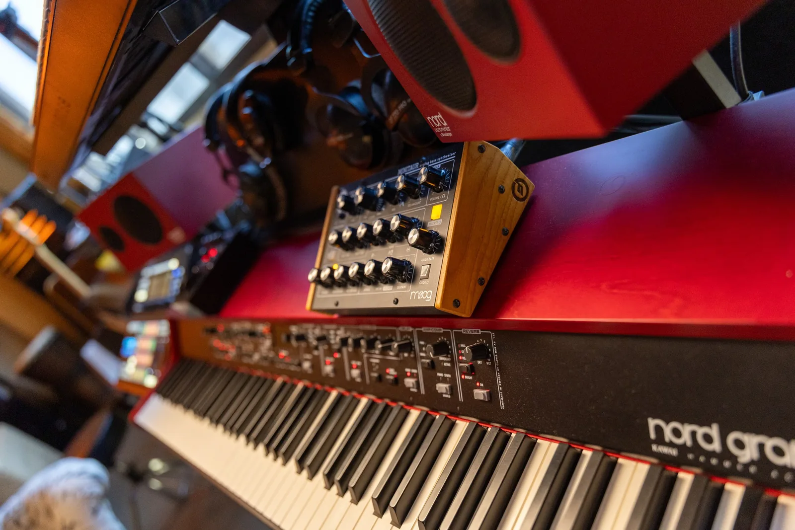 Photo of a studio keyboard corner showing a Moog Minitaur analog bass synthesizer mounted above a Nord Grand stage piano.