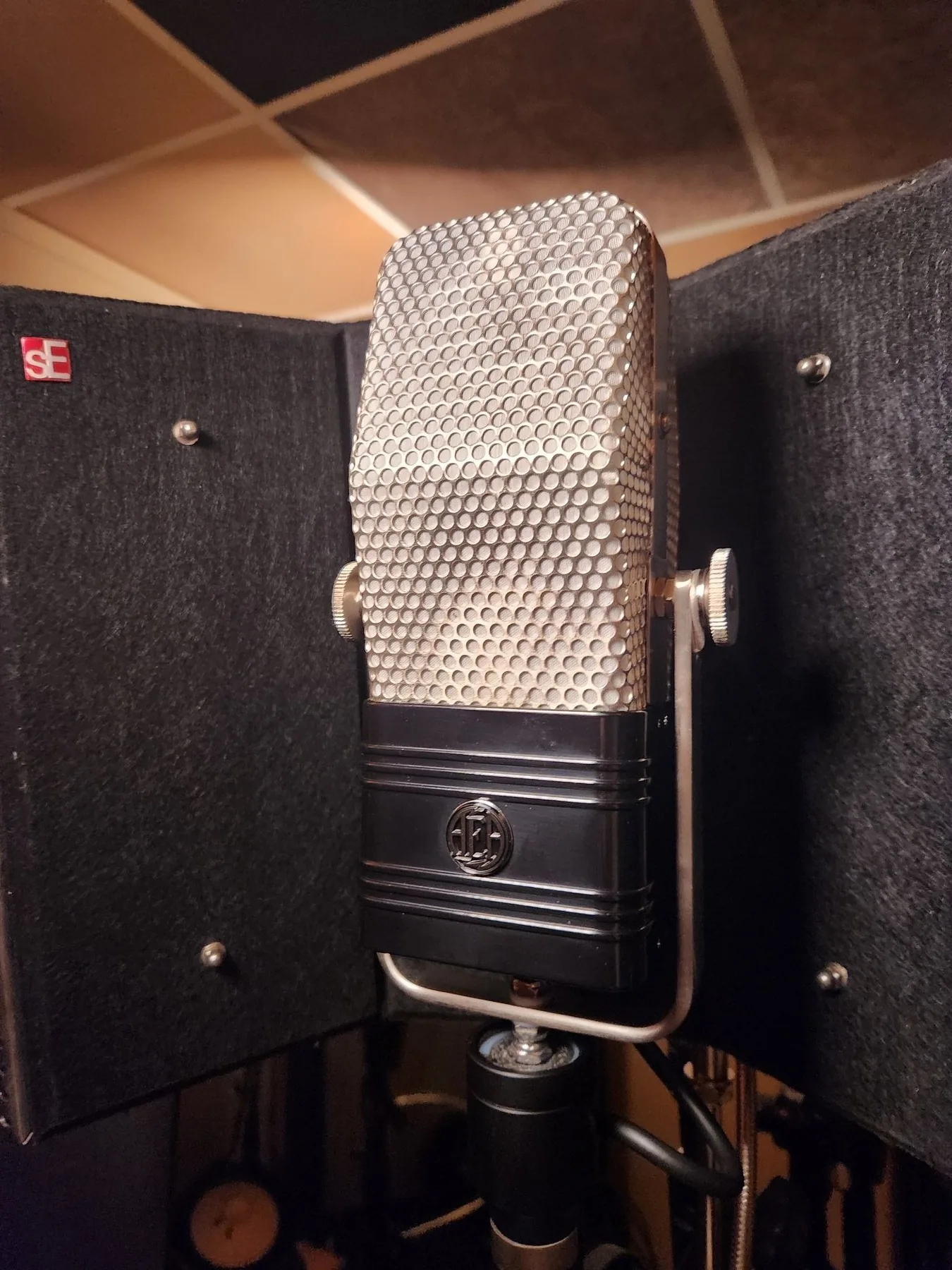 Photo of an AEA R44CE ribbon microphone, a large vintage-style microphone with an open mesh grille and rectangular body.