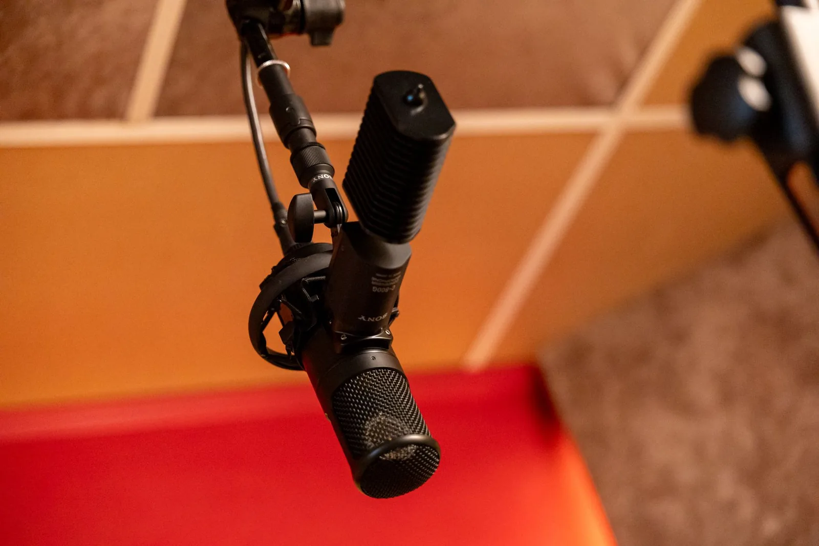 Photo of a Sony C-800G large-diaphragm tube condenser microphone with its external power supply or cooling unit visible alongside the mic body.
