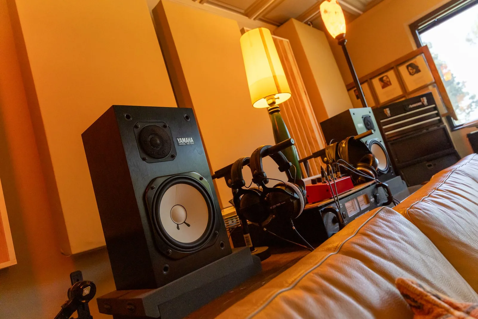 Photo of a pair of Yamaha NS-10 passive nearfield studio monitors, white-cone two-way speakers mounted horizontally on stands.